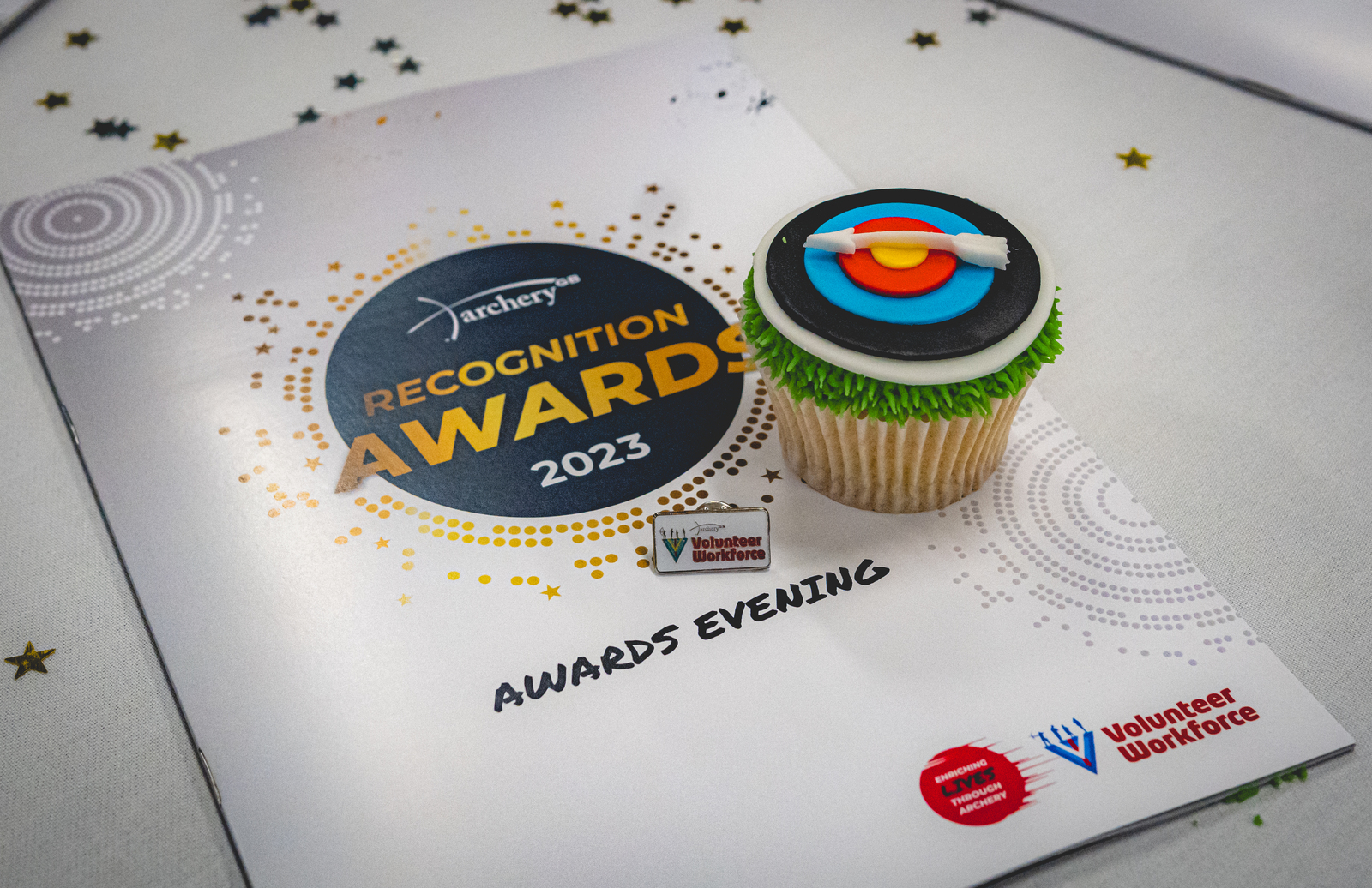 Awards booklet, cake and badge